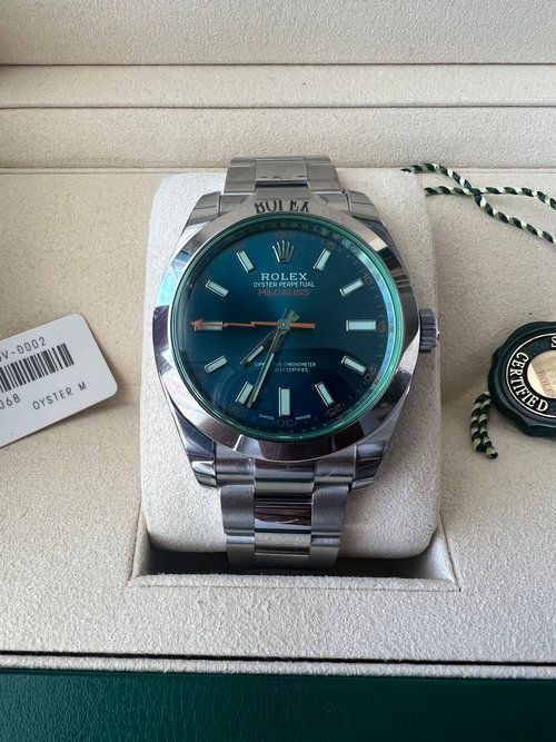 A silver rolex watch with a blue face