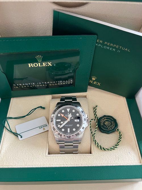 A rolex watch is sitting in a green box.