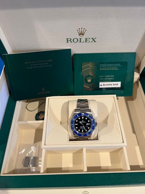 A rolex watch is sitting inside of a box.