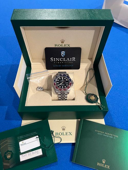 A rolex watch is in a green box