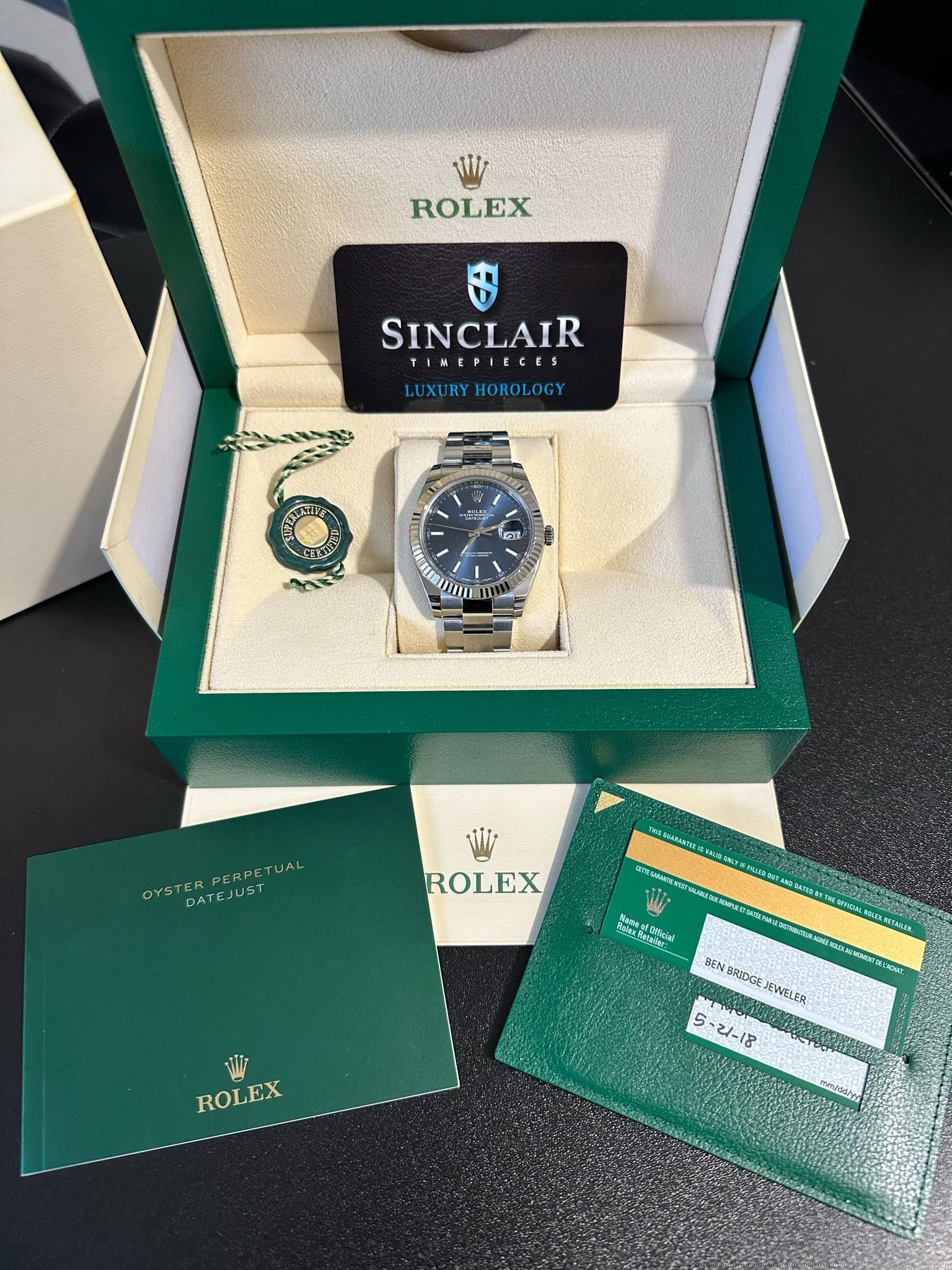 A rolex watch in a box with a certificate