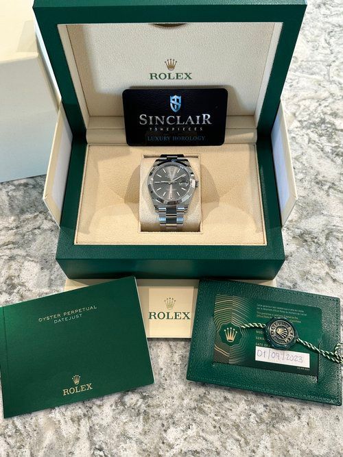 A rolex watch is in a box with a certificate of authenticity.