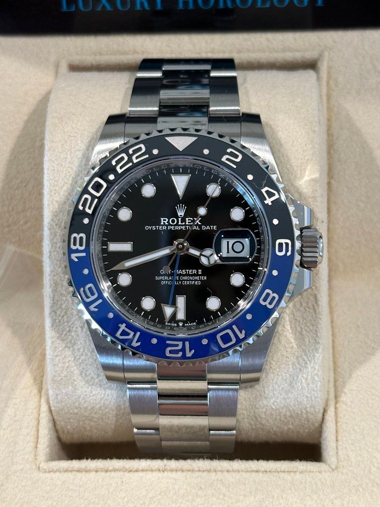 A silver and blue rolex watch with a black face