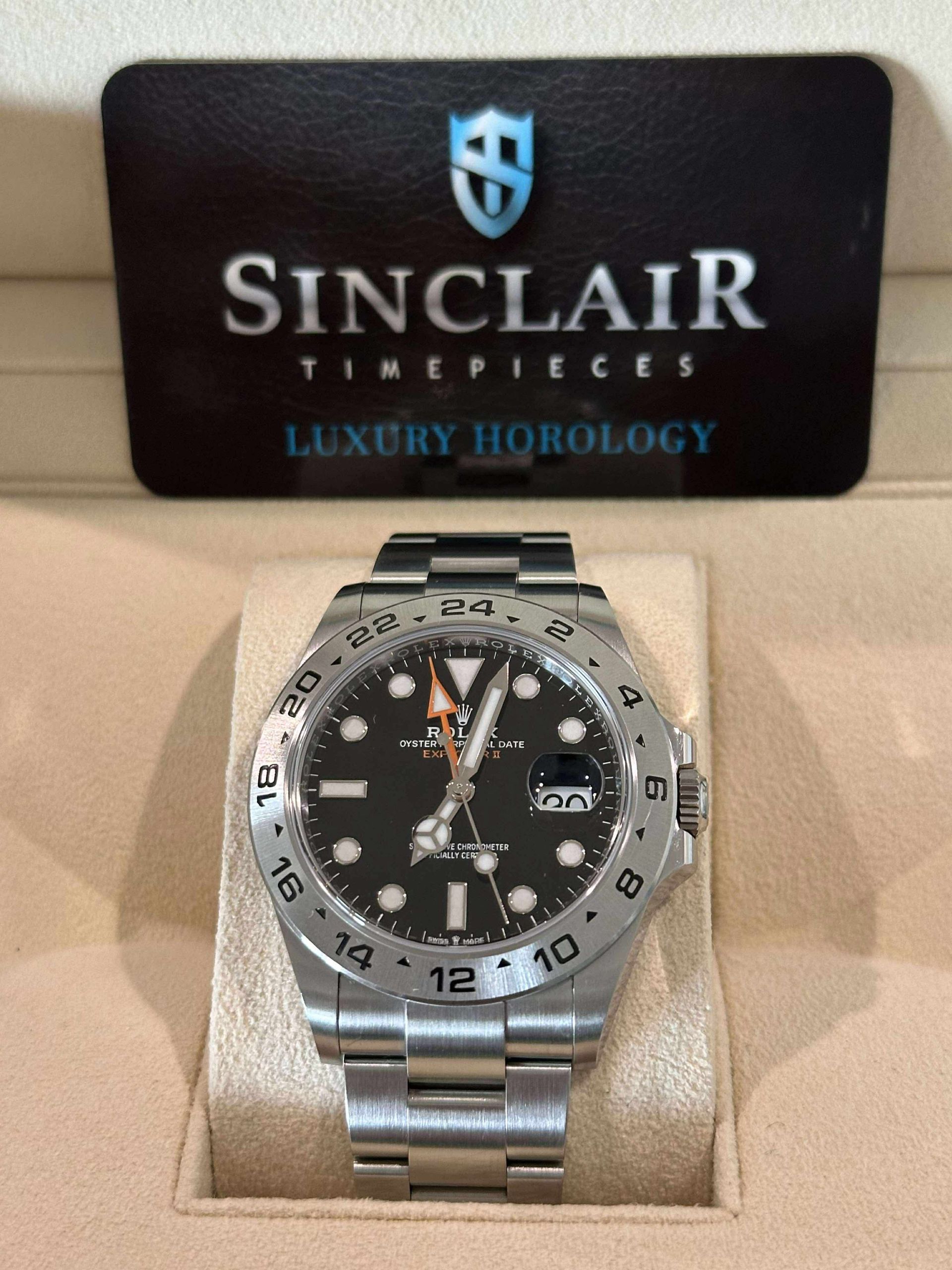 A silver and black rolex watch sits in a box