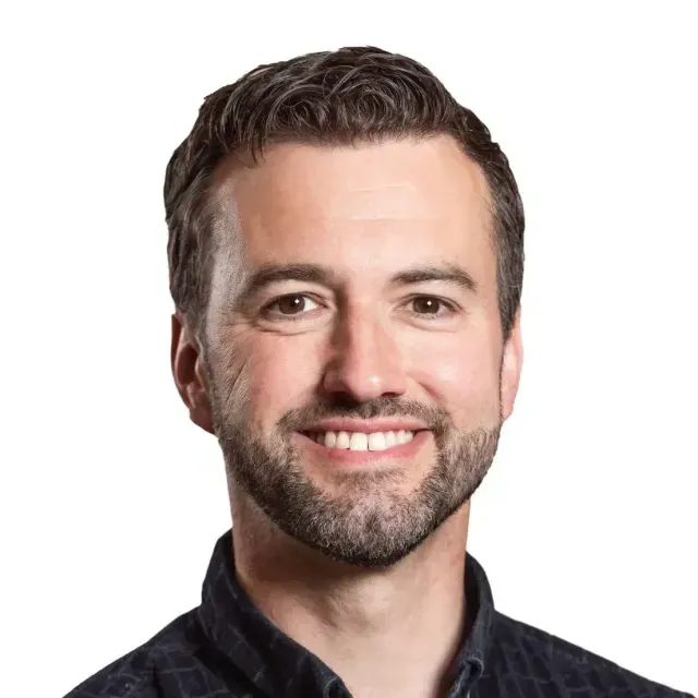 A man with a beard is smiling for the camera