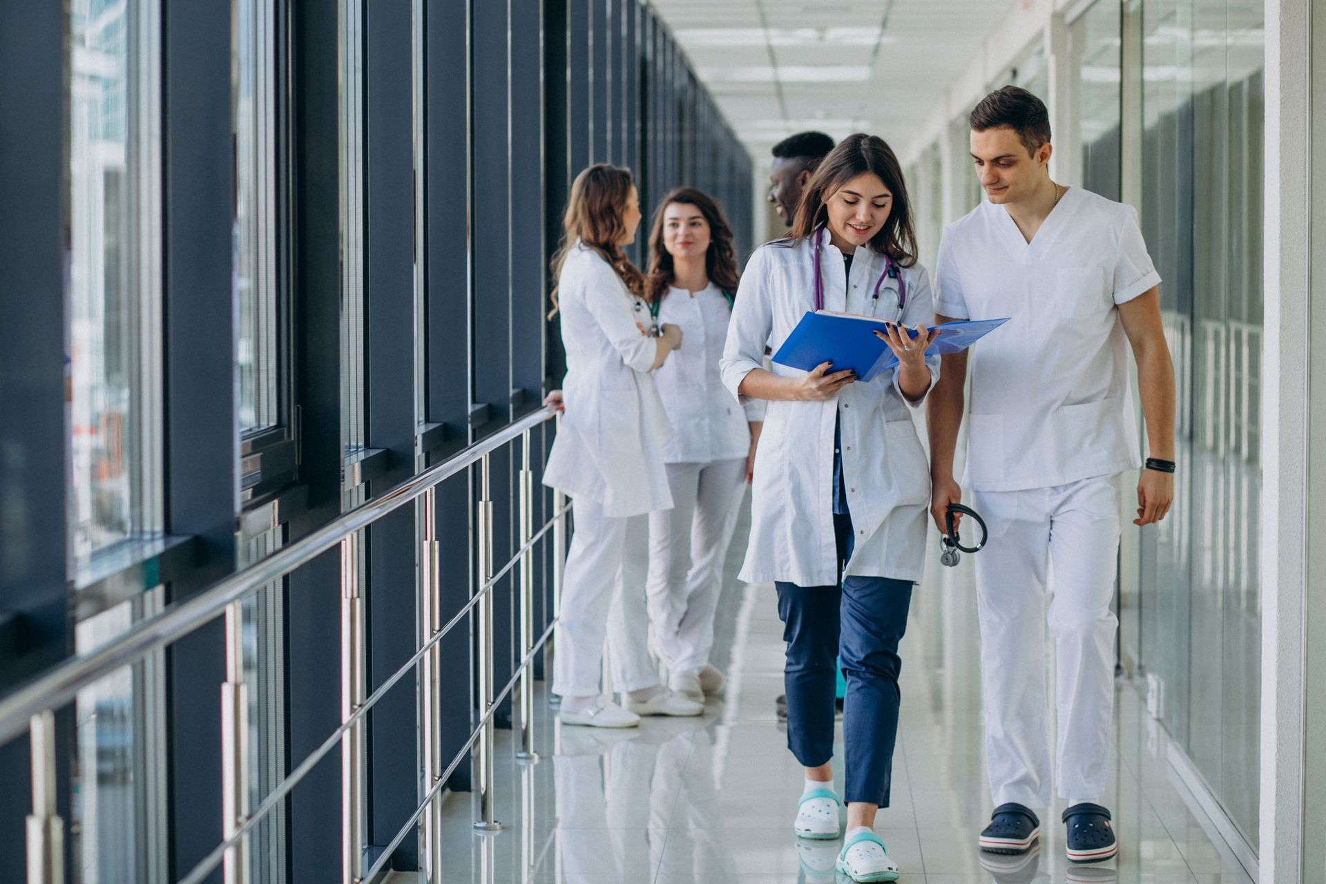 A group of doctors and nurses are walking down a hospital hallway.