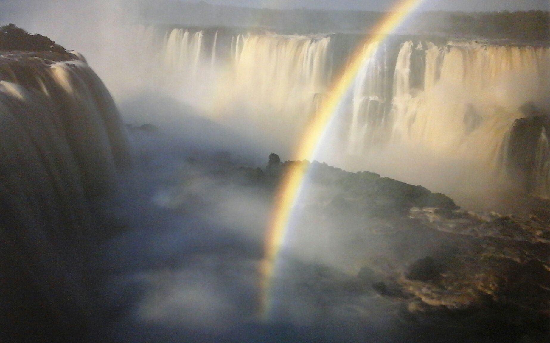 A waterfall with a double rainbow in the background
