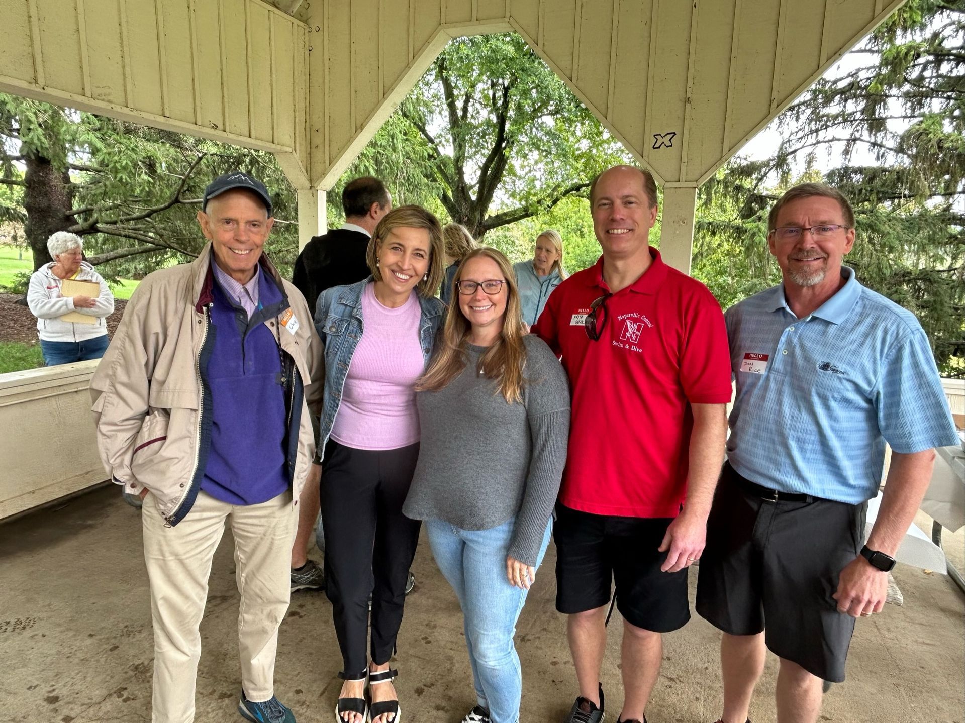 A group of people are posing for a picture under a gazebo.