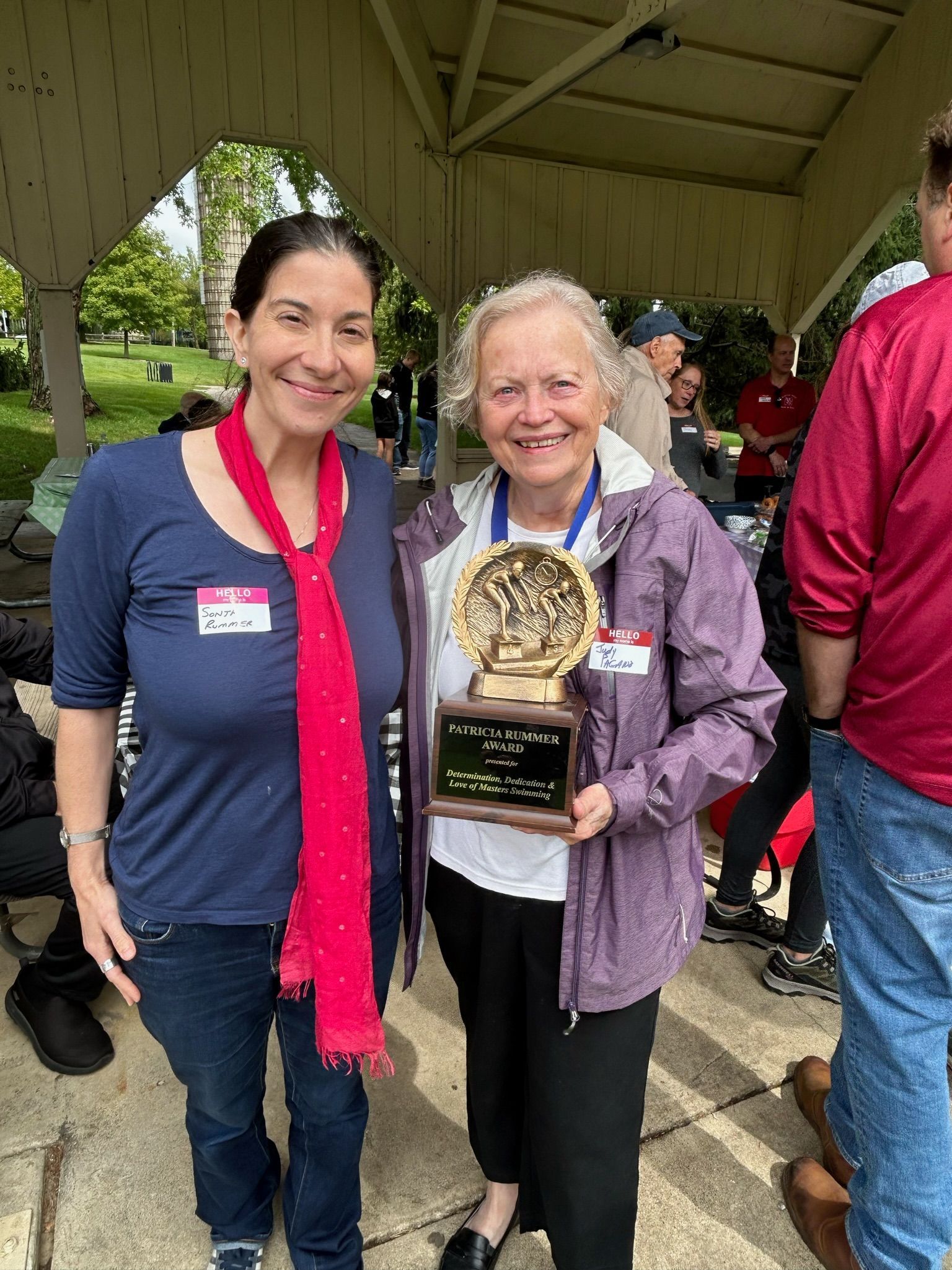 Two women standing next to each other holding a trophy