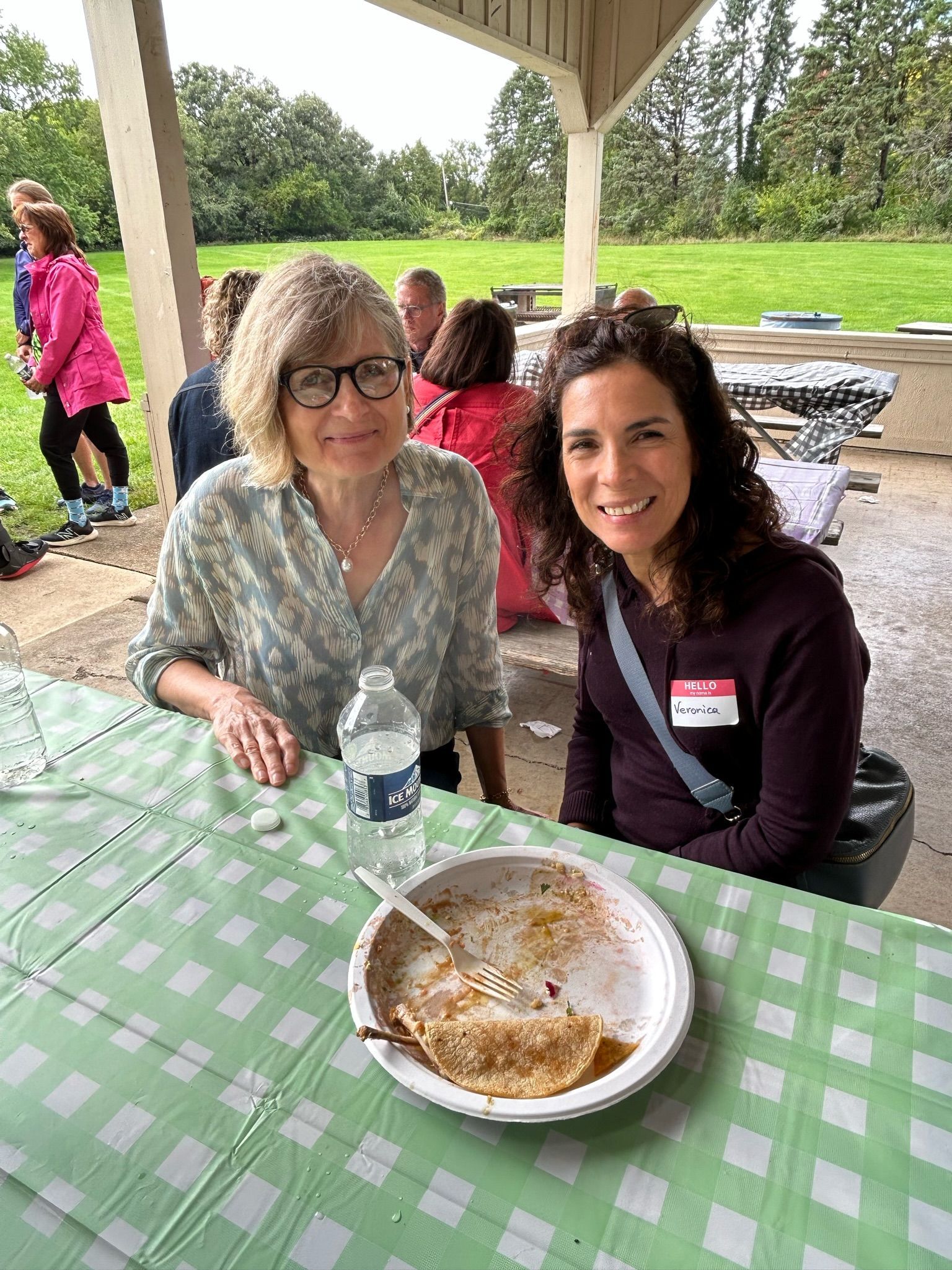 Two women are sitting at a table with a plate of food.