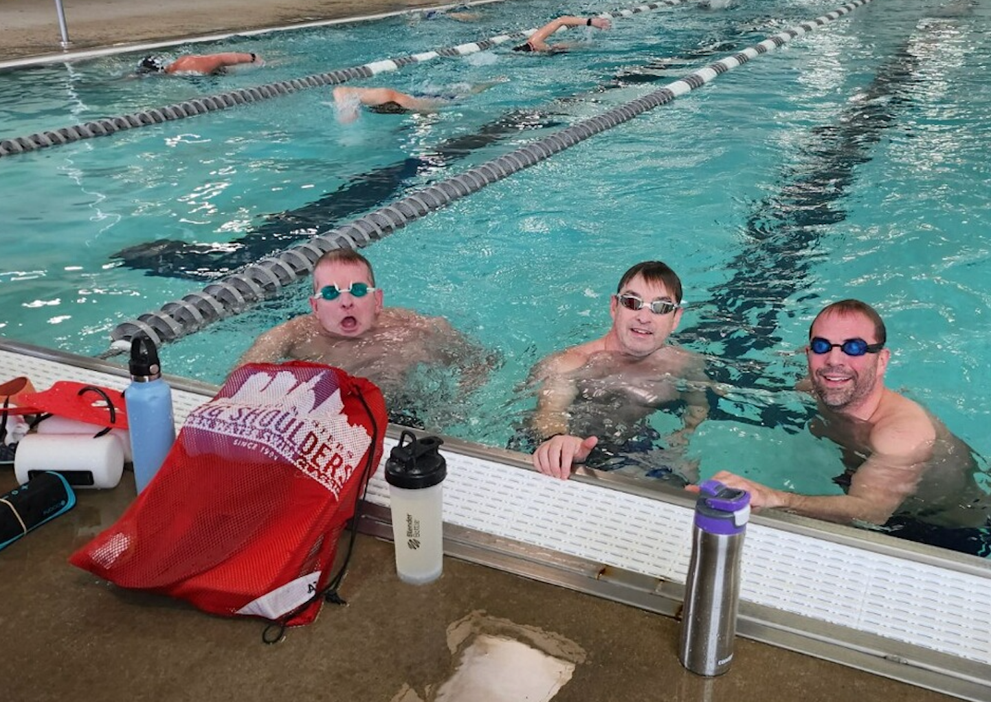 A group of men are swimming in a swimming pool.
