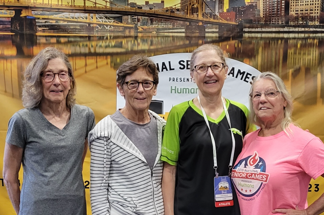 A group of four older women are posing for a picture.