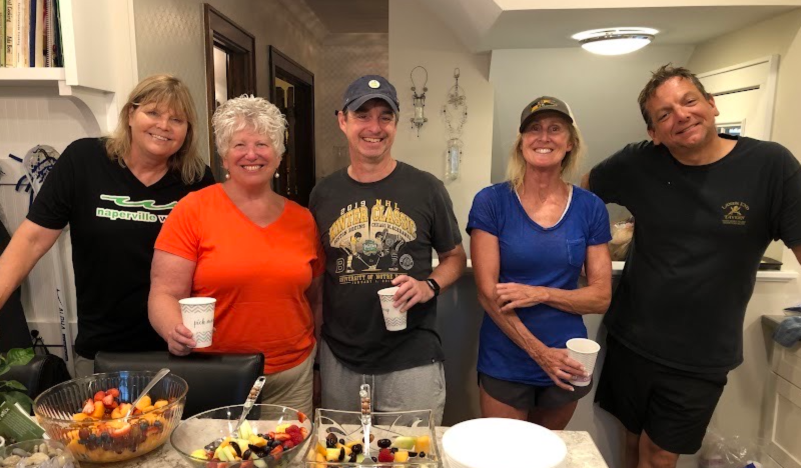 A group of people are posing for a picture in a kitchen.