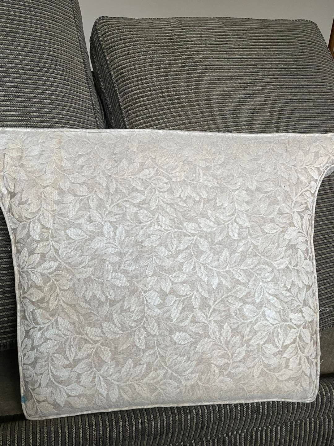 Light gray patterned throw pillow on a dark gray sofa with matching cushions