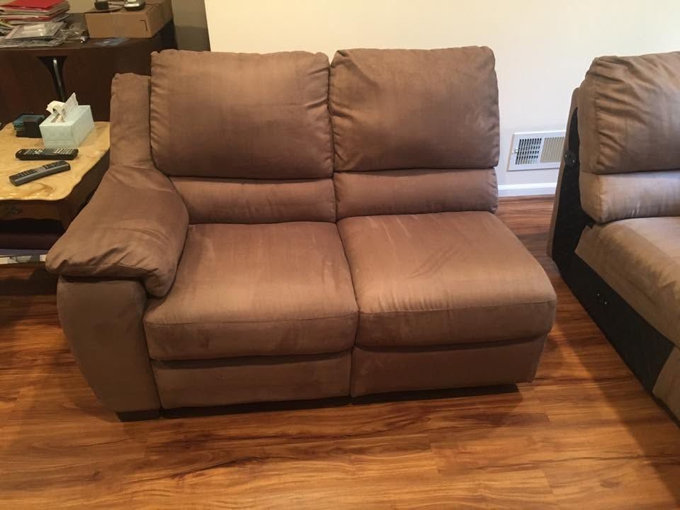 Brown two-seat recliner sofa in a living room with hardwood floor