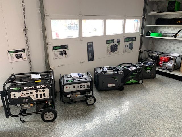 Generators on display inside a store, with white walls and a gray floor.