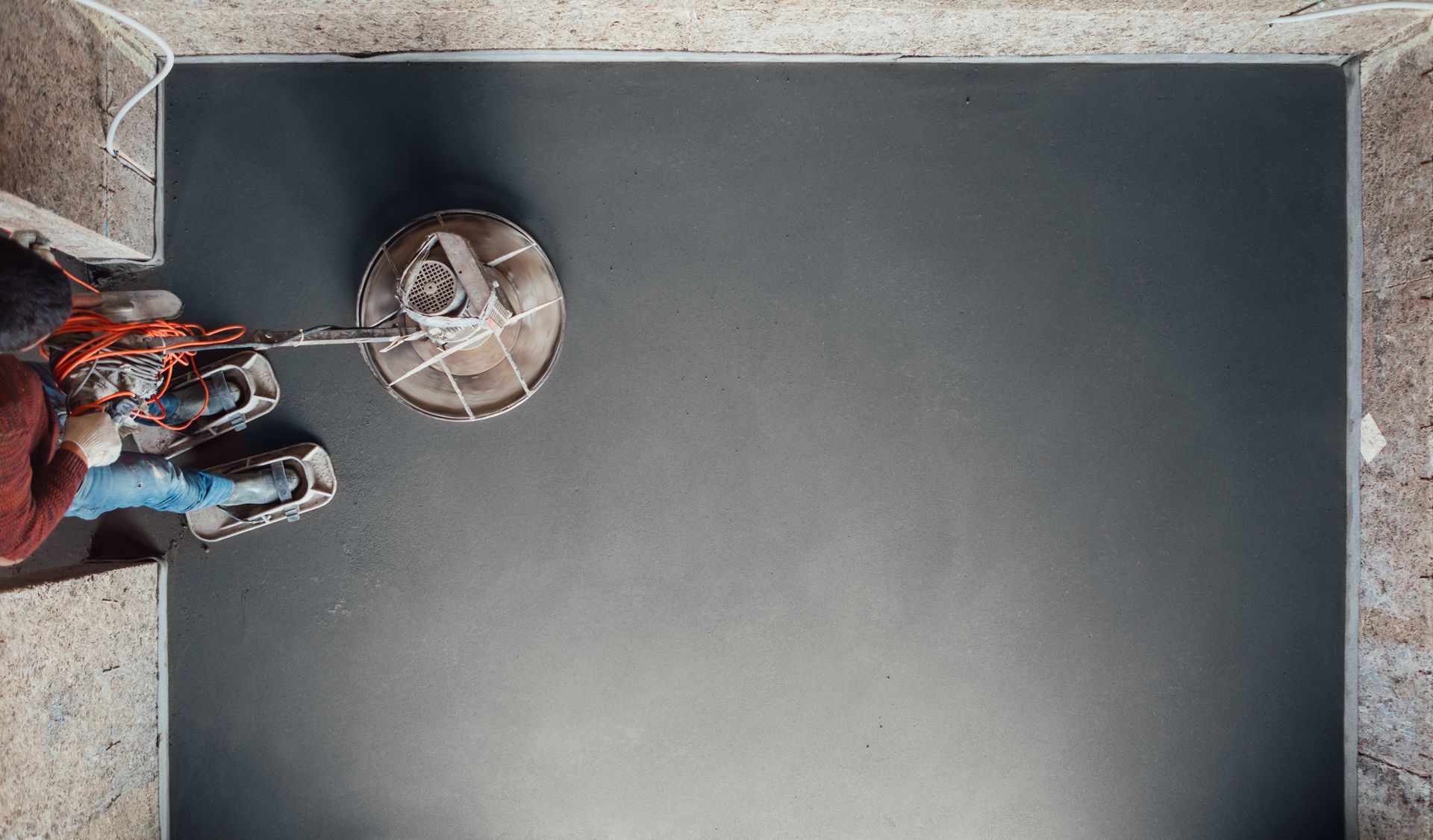 Person using a floor buffer to polish a dark floor.