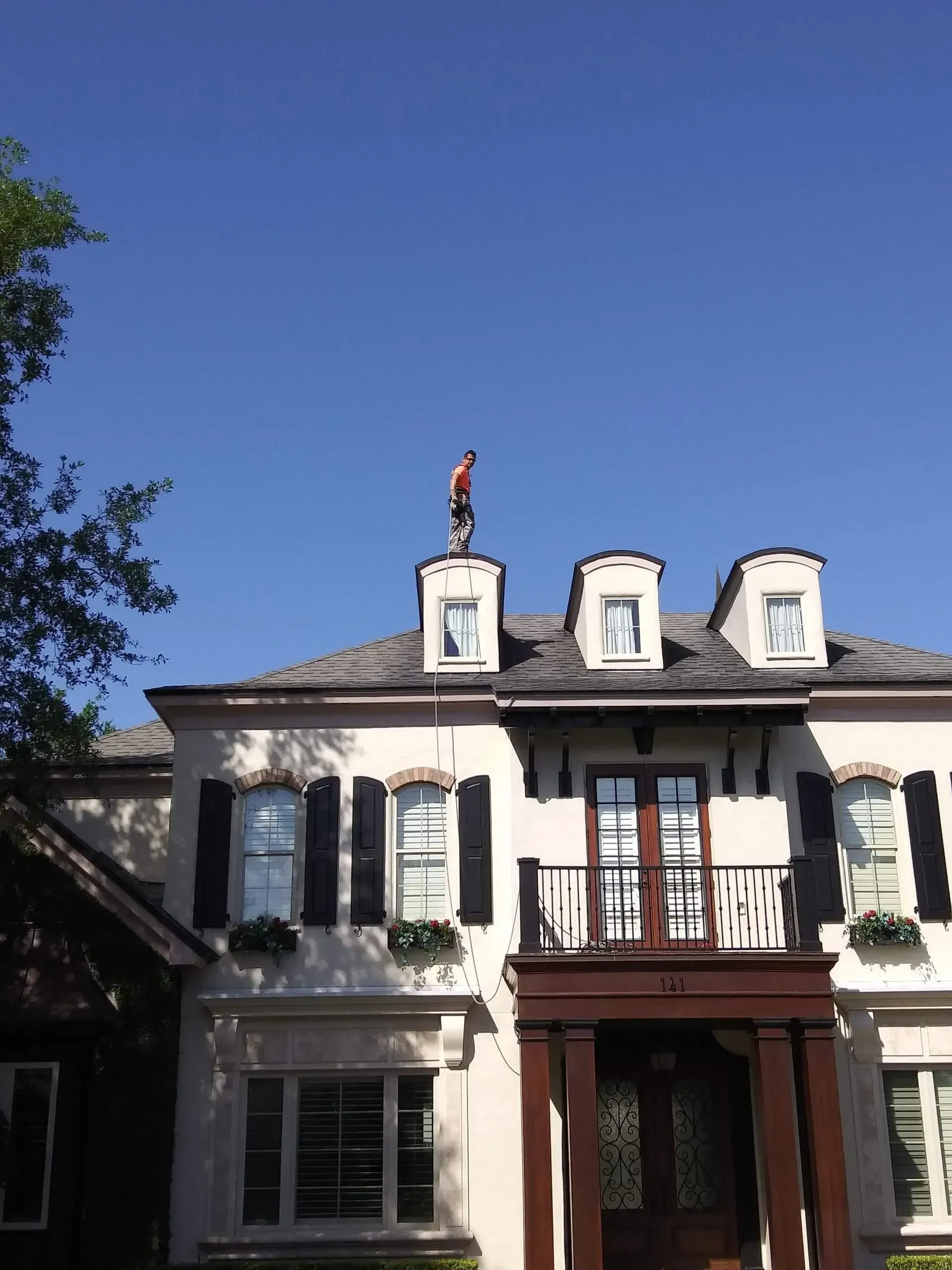 A man is standing on the roof of a house