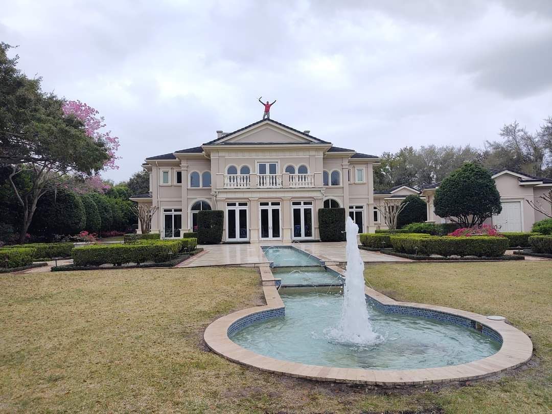 A large house with a fountain in front of it.