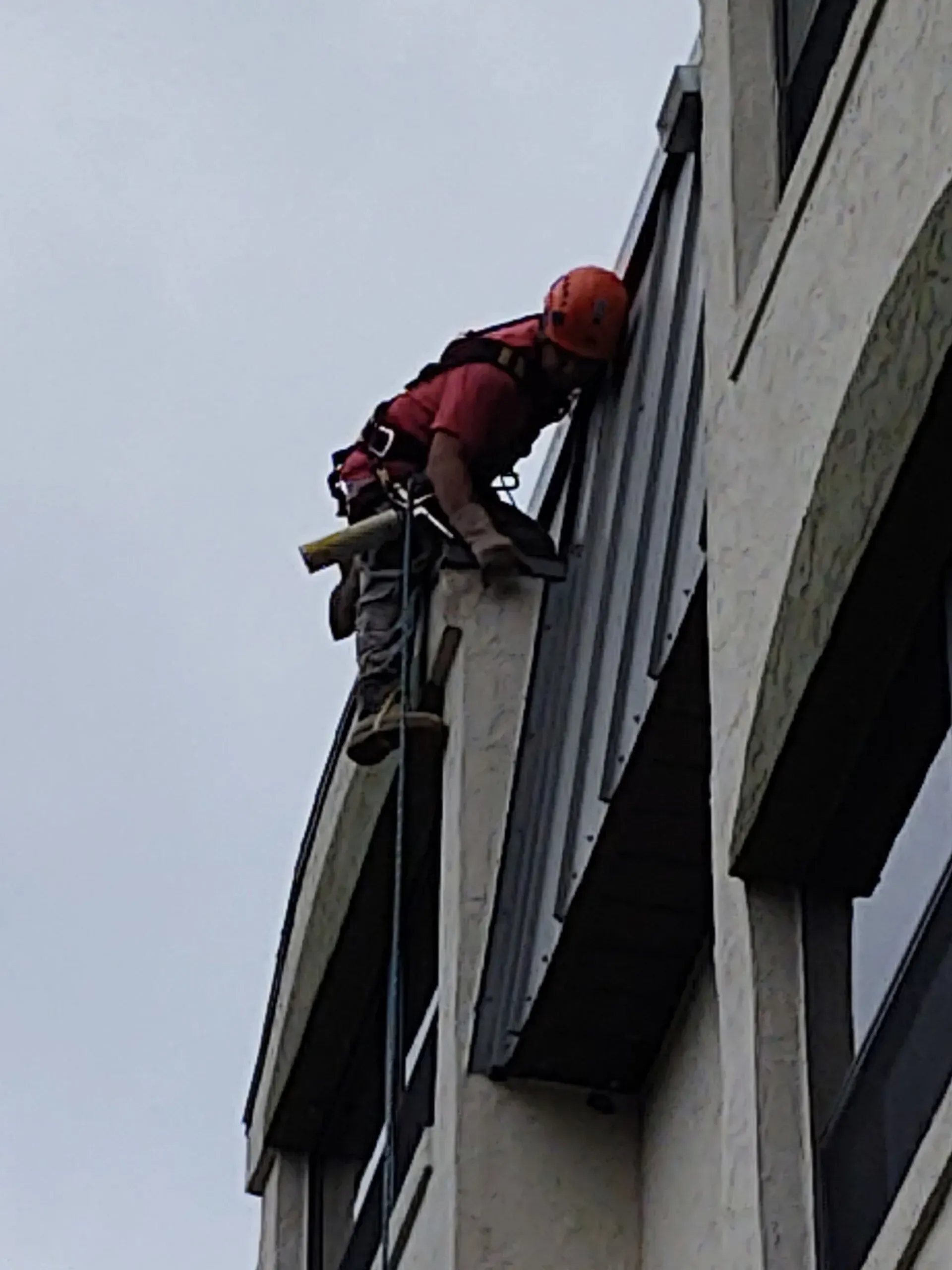 Edgar Nunez is climbing up the side of a building