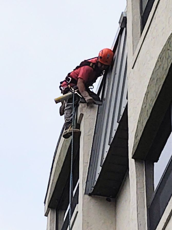 A man is climbing up the side of a building