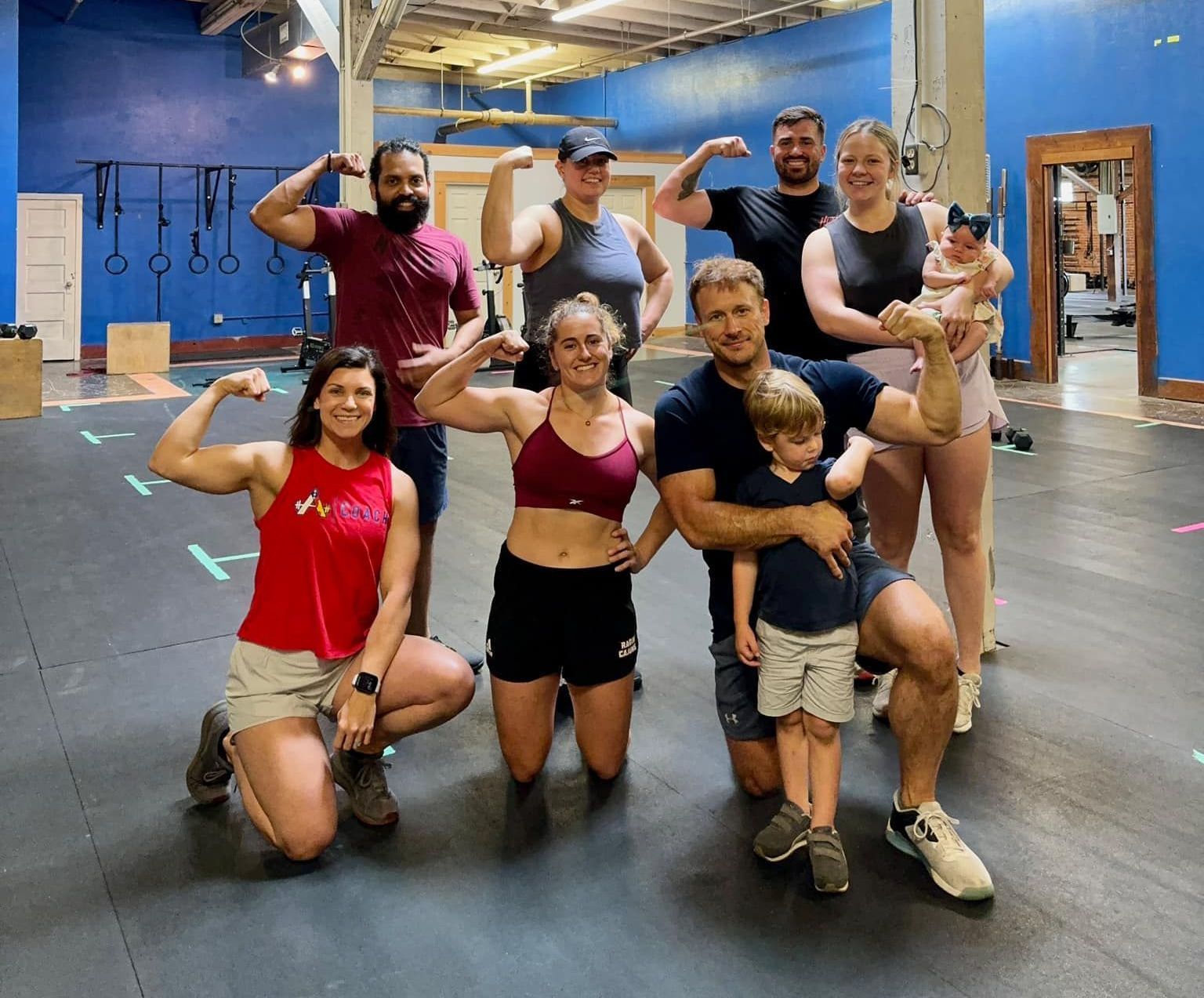 A group of people are posing for a picture in a gym.