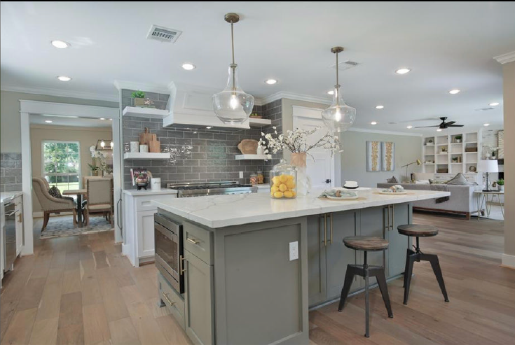 Bright modern kitchen with gray island, pendant lights, and white cabinetry