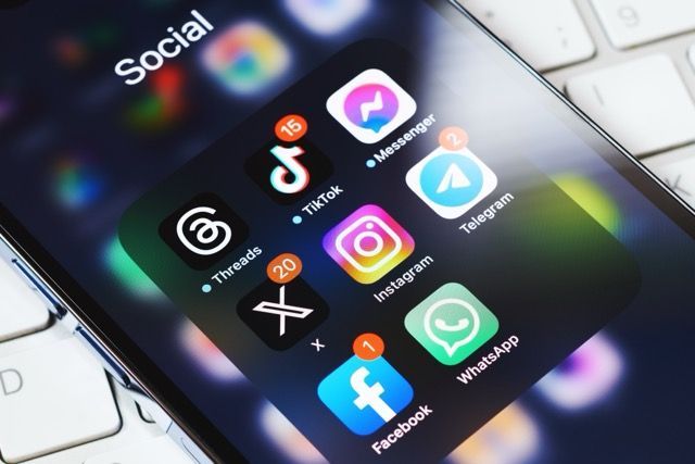 Smartphone screen showing a social media app folder with TikTok, Instagram, Facebook, WhatsApp, and other app icons