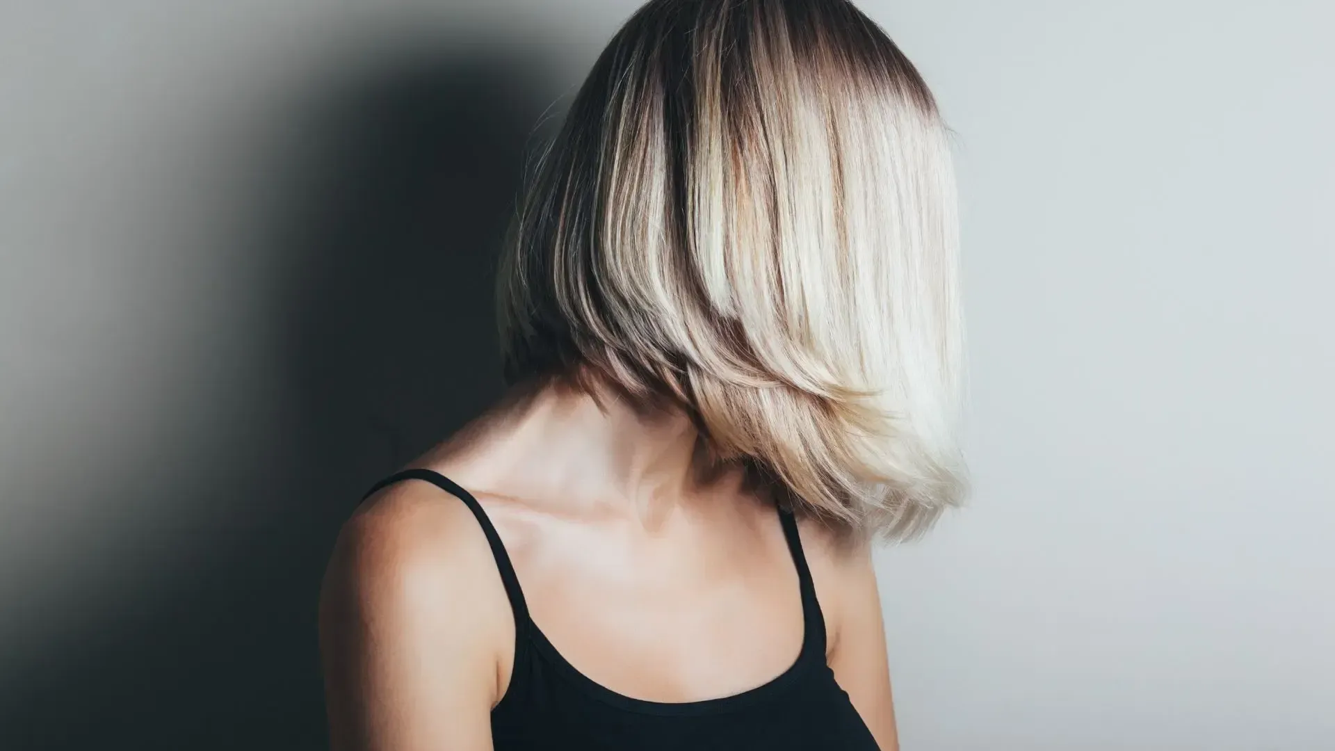 A woman with curly hair is wearing a black top