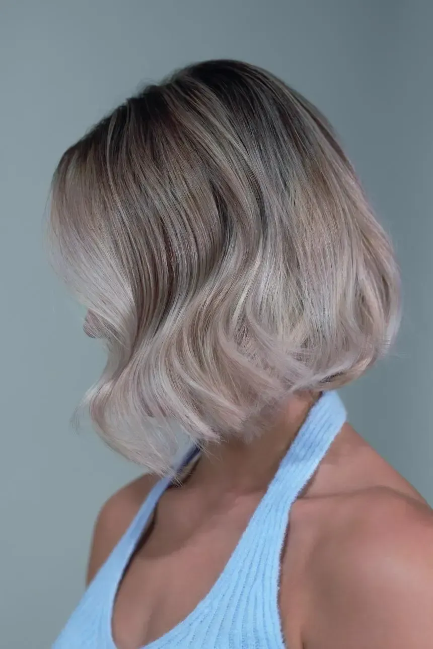 A woman with short blonde hair is wearing a blue tank top.
