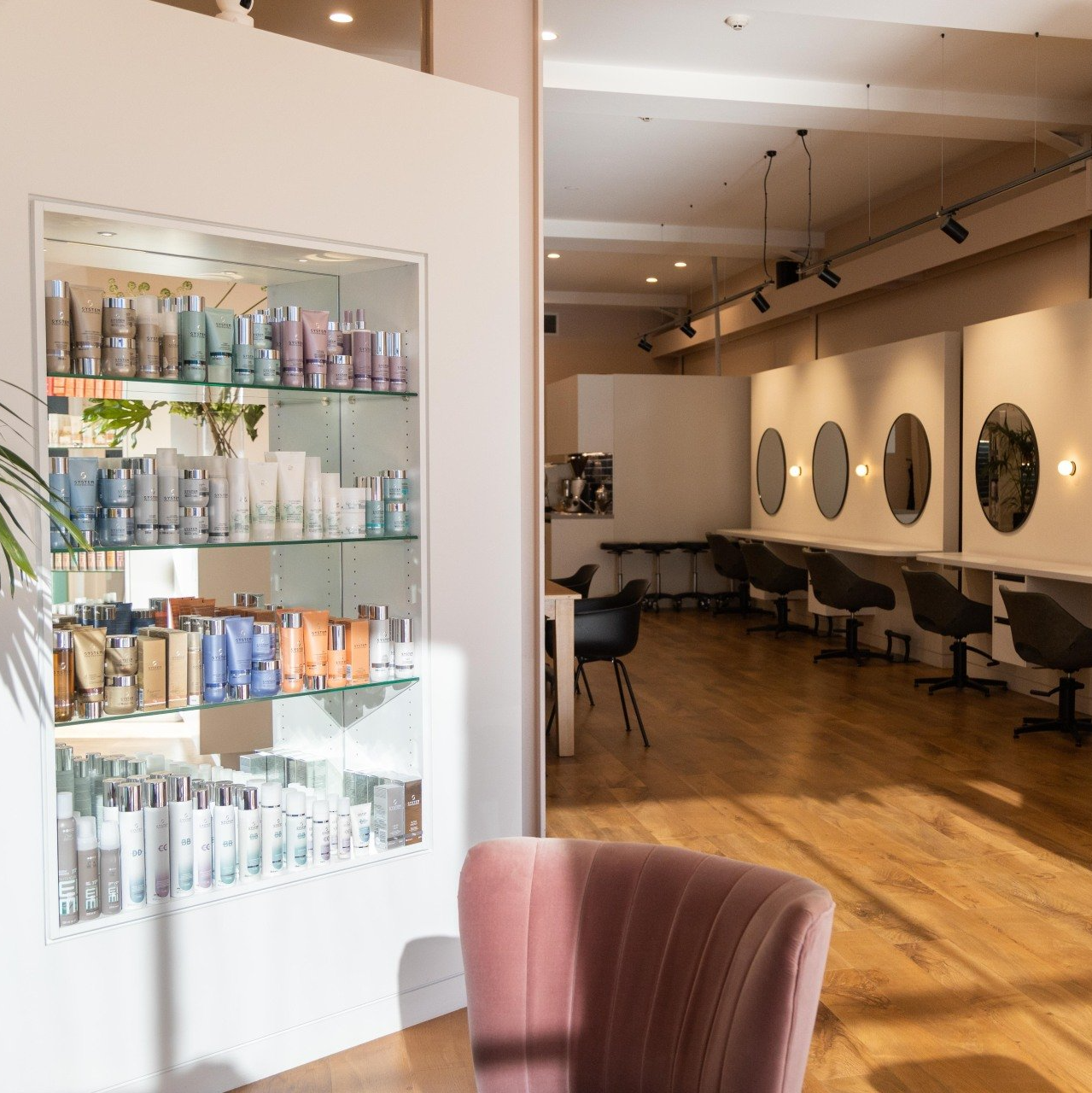 A salon with a pink chair and shelves full of hair products