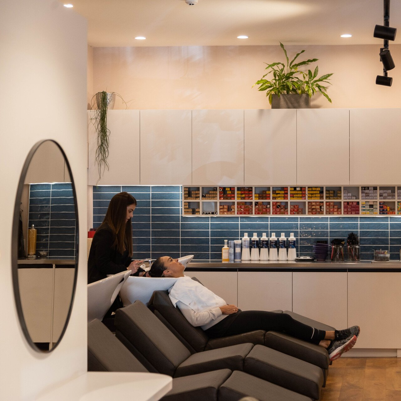 A woman is washing a man 's hair in a salon