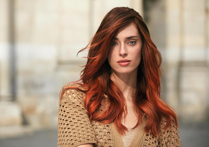 A Woman With Red Hair And A Sweater On