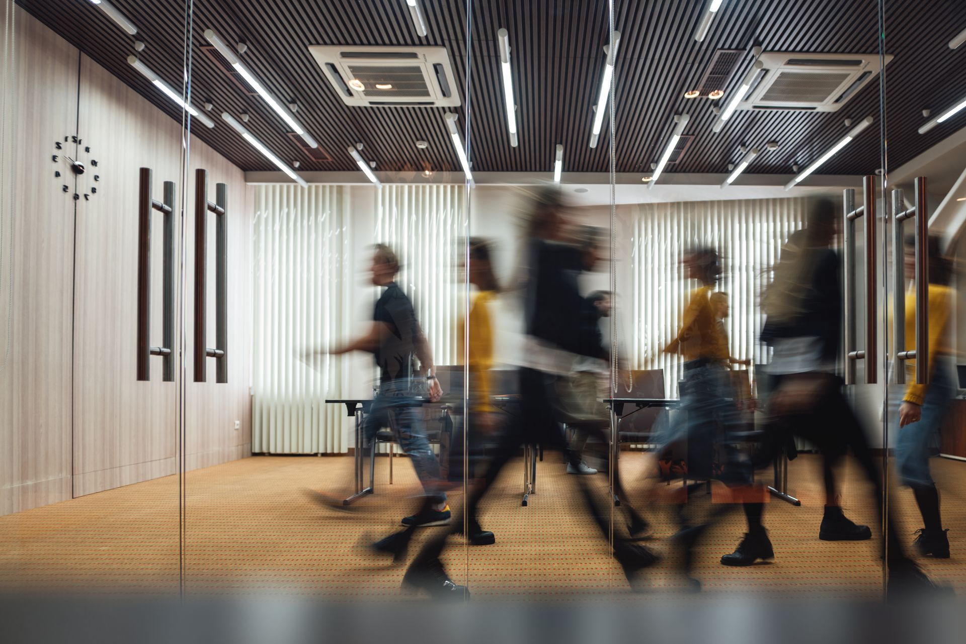Un groupe de personnes se promène dans une salle de conférence.