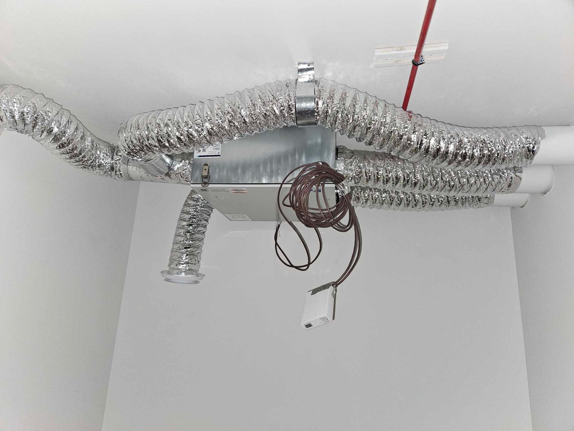 Un tas de conduits sont suspendus au plafond d'une pièce.