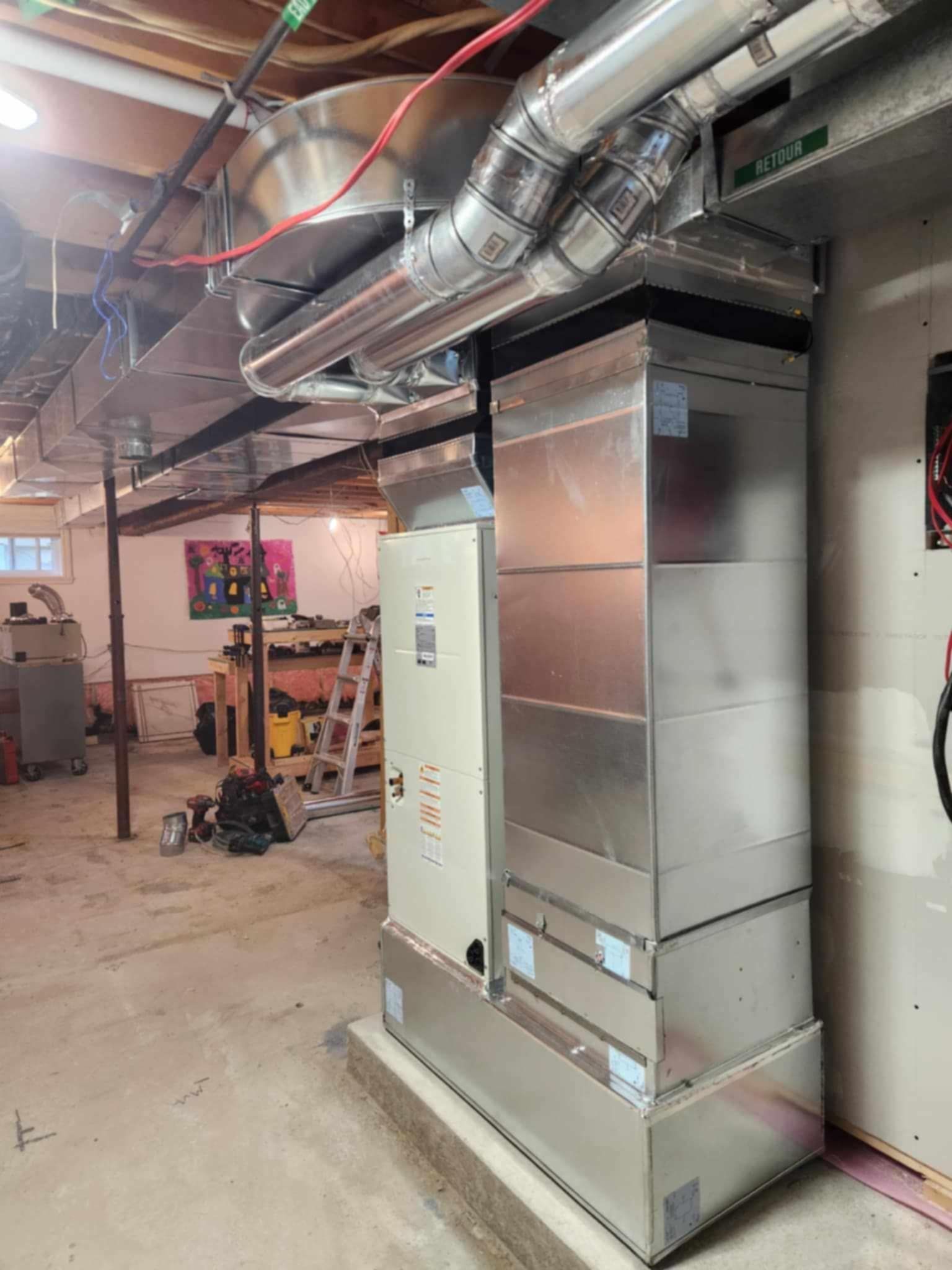 Un grand climatiseur en acier inoxydable se trouve dans un sous-sol.