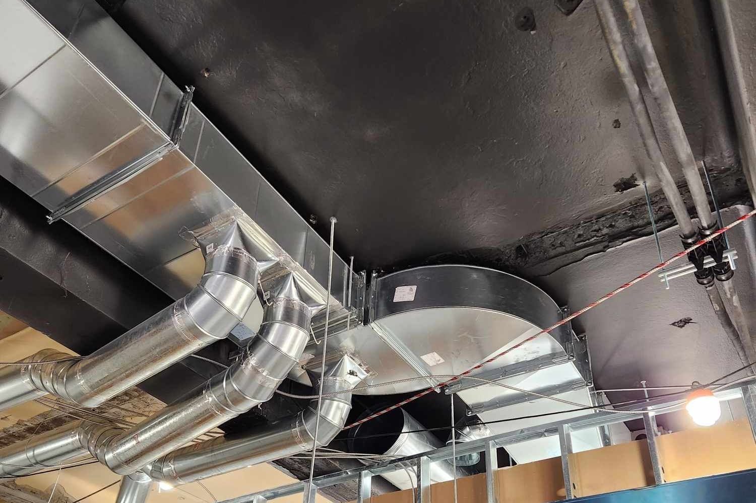 Un plafond avec beaucoup de tuyaux suspendus.