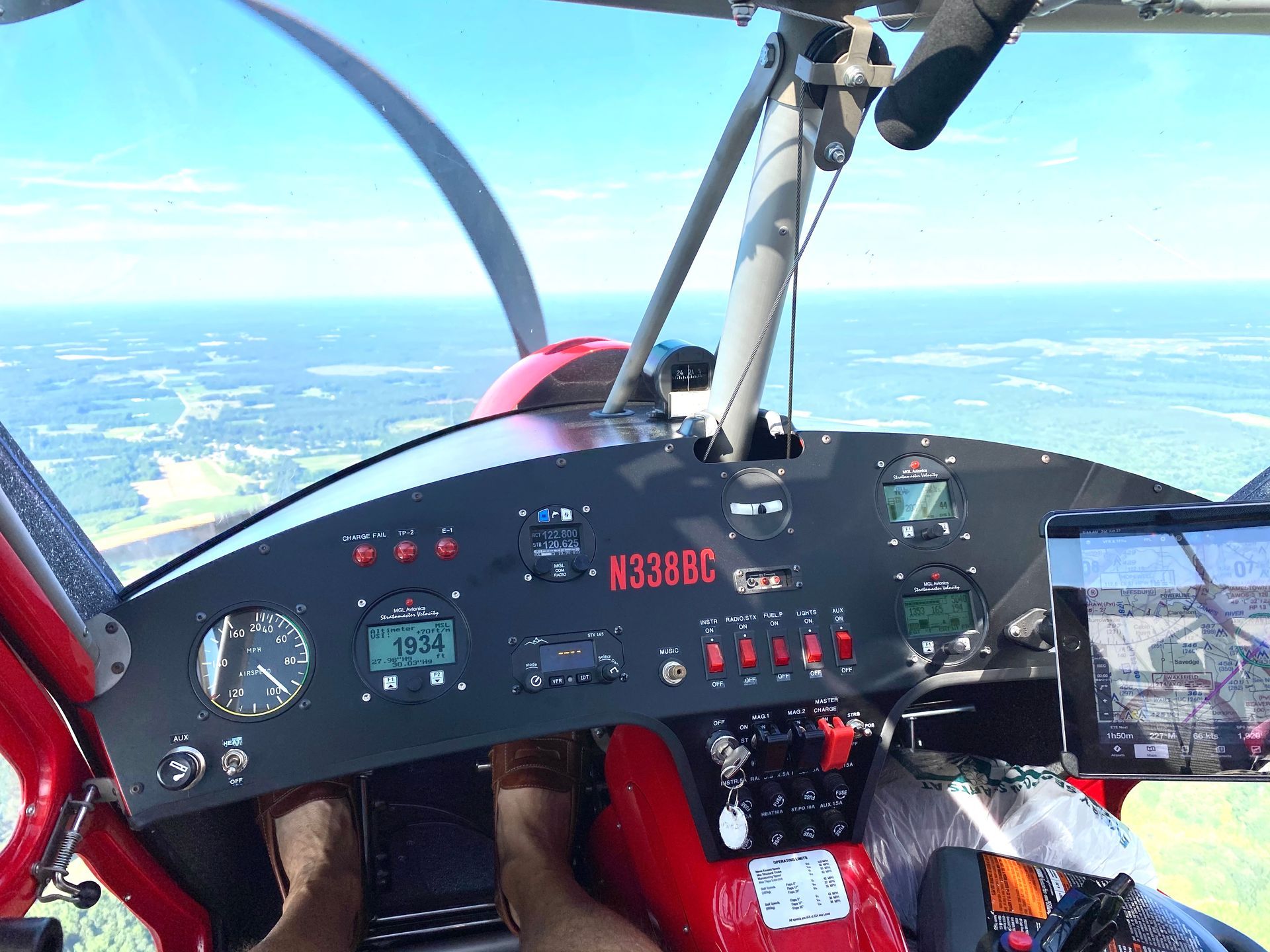 Cockpit view from a small plane, with instrument panel and sky visible through the windshield.
