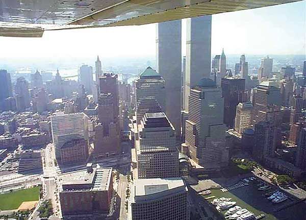 Aerial view of a dense city skyline with tall skyscrapers under bright daylight.