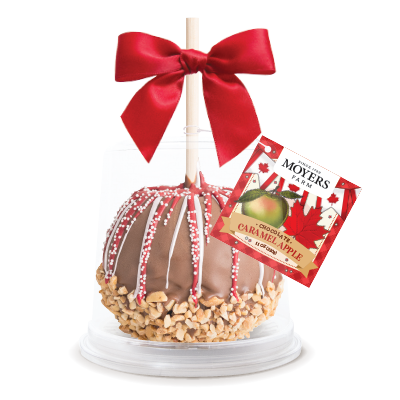 Gift basket with chocolate caramel apple, red bow, and “Merry Christmas” tag on a white stand