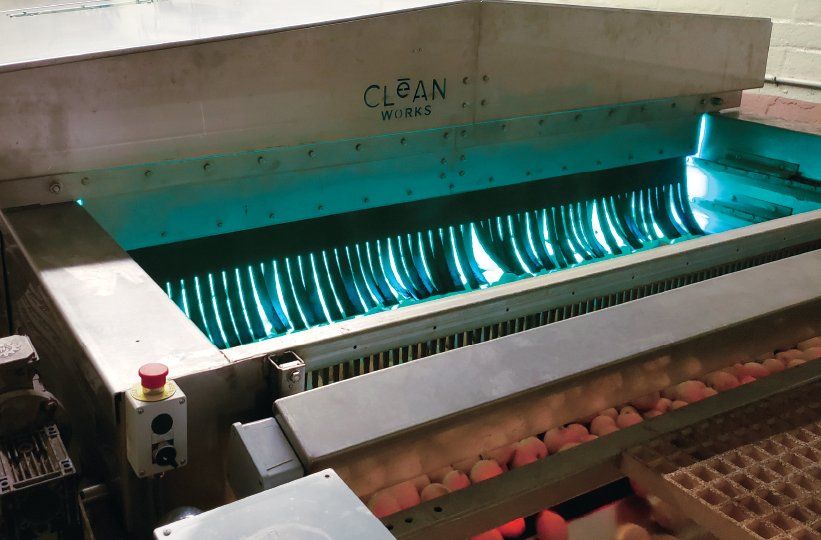 Industrial machine scanning glowing blue items on a conveyor belt