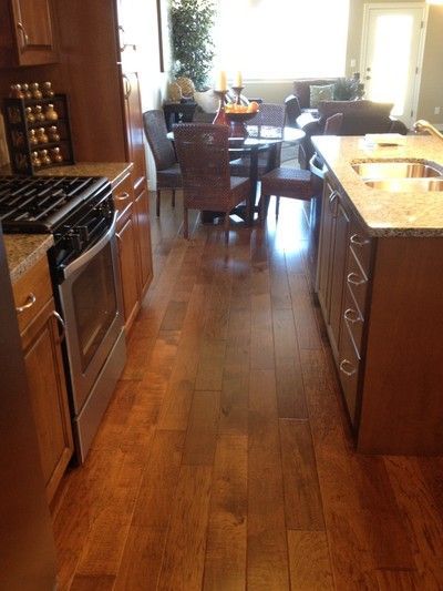 Open kitchen and dining area with granite island, wicker chairs, and wood flooring