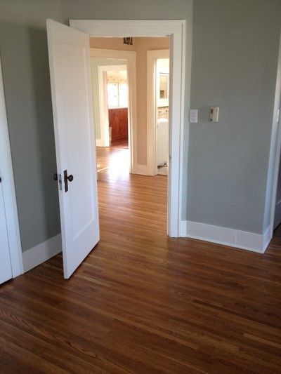 Interior view through open doorways with hardwood floors, gray walls, and white trim