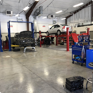 A car is sitting on a lift in a garage. | Patterson Custom Diesel/Automotive