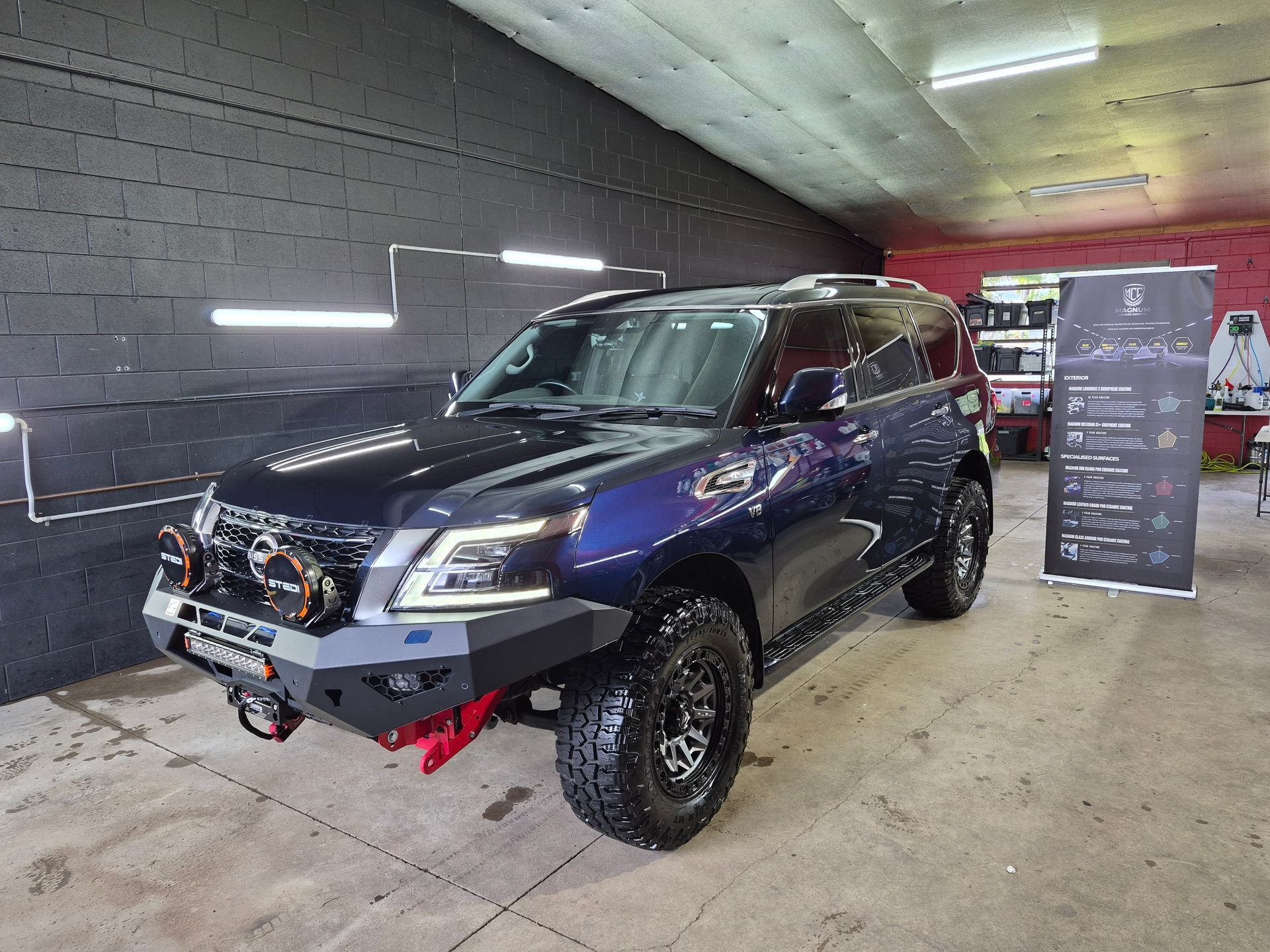 Blue off-road SUV with Lifted Suspension and Red Tow Hooks — Mobile Club Cars Cairns in Earlville, QLD