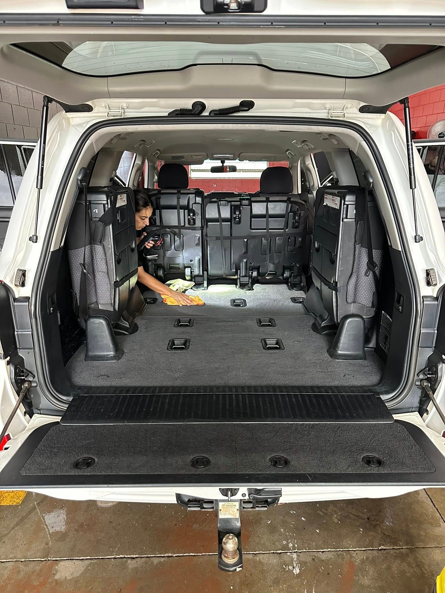 A Person is Cleaning the Back of a White SUV — Mobile Club Cars Cairns in Earlville, QLD
