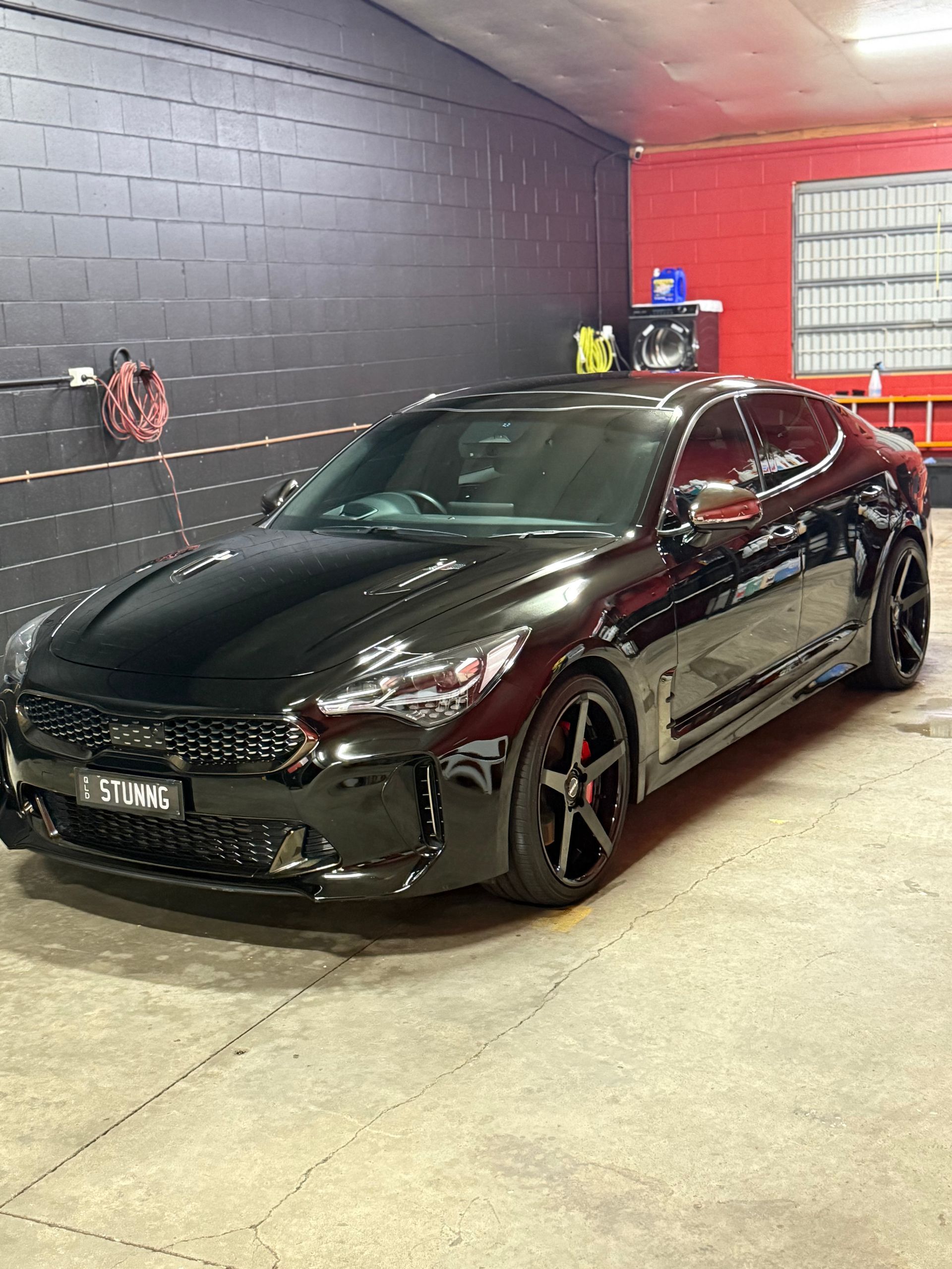 Black KIA Stinger Parked Indoors With Red Accents — Mobile Club Cars Cairns in Earlville, QLD