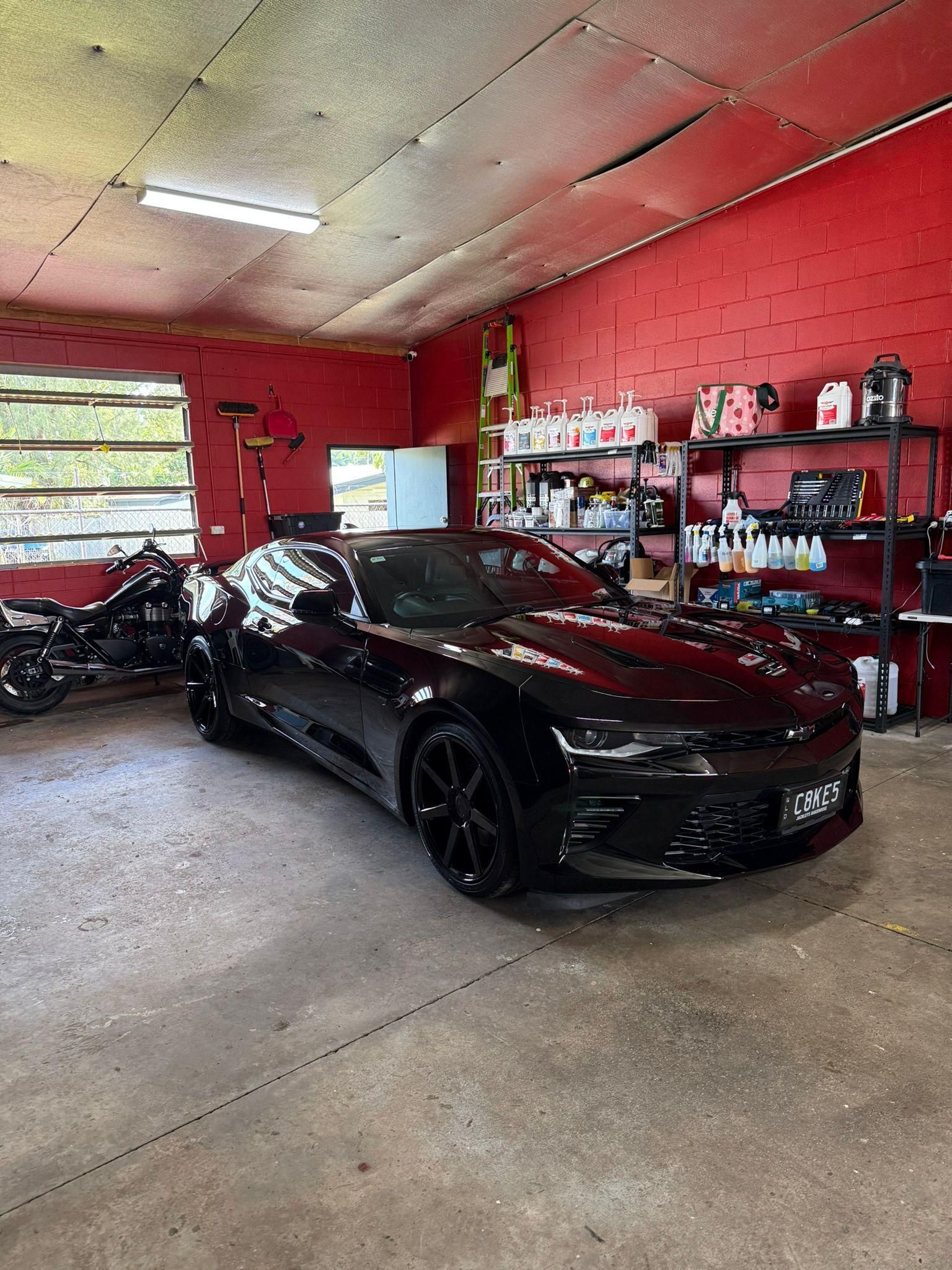 Black Sports Car in a Garage with Detailing Products — Mobile Club Cars Cairns in Earlville, QLD