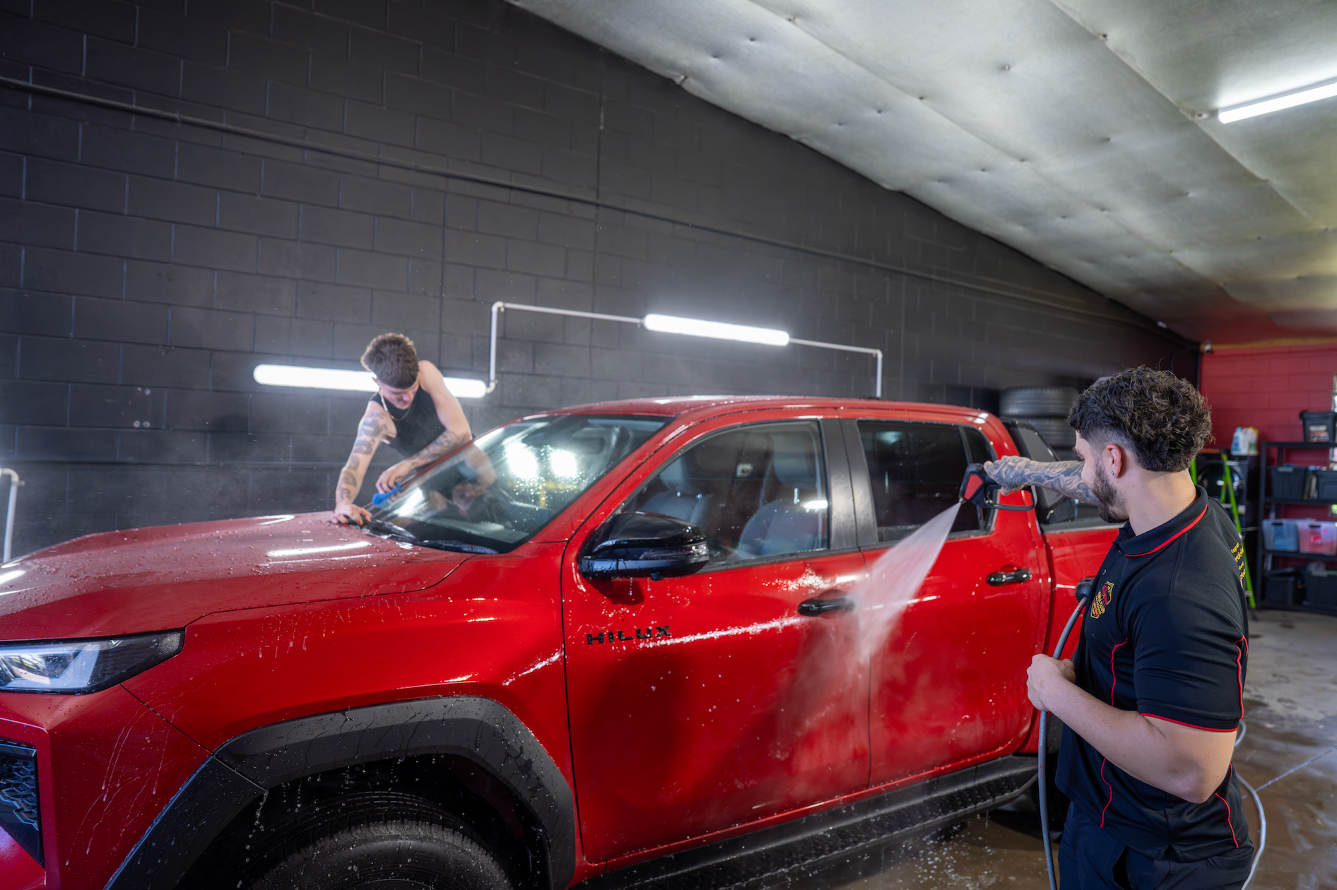 Two People Washing a Red Suv Inside a Car Wash Bay — Mobile Club Cars Cairns in Earlville, QLD