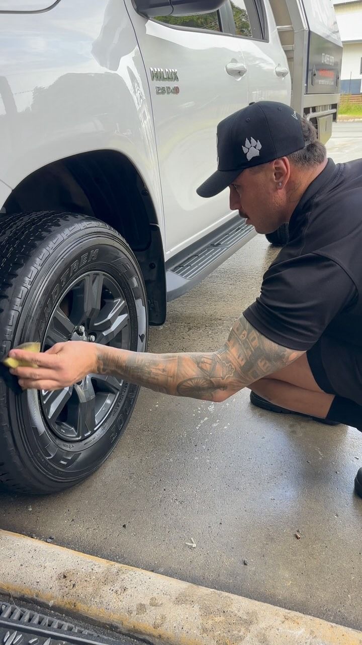 Man Cleaning a White Truck's Tire With a Sponge — Mobile Club Cars Cairns in Earlville, QLD